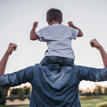 Hombre con su hijo a hombros sacando bíceps
