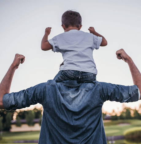 Hombre con su hijo a hombros sacando bíceps