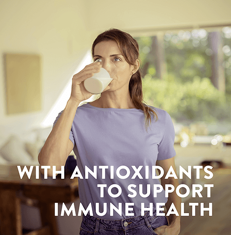 A woman drinking a glass of ensure with on image text highlighting the antioxidants for immunity support