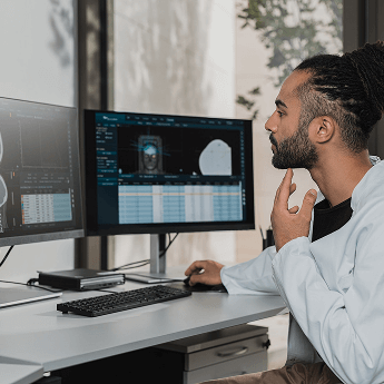 Een man bestudeert wetenschappelijk onderzoek naar de menselijke gezondheid aan een monitor op een bureau