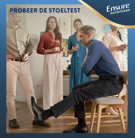 Een man die zijn armen over elkaar slaat en één been naar voren legt terwijl hij de stoeluitdaging probeert te doen