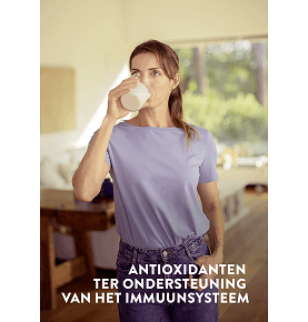 Een vrouw drinkt een wit glas Pediasure Vanilla in haar woonkamer met de woorden 'met antioxidanten ter ondersteuning van uw immuunsysteem'