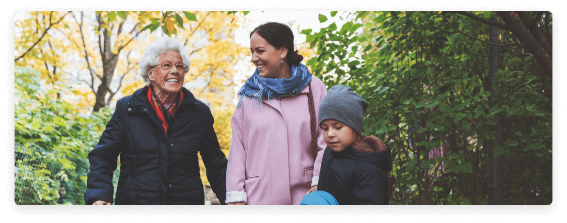 Vieillesse, âge moyen et enfant ensemble souriant lors d'une promenade dans la forêt avec leurs manteaux
